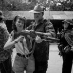 VIET NAM. David CHRISTIAN teaching his daughter to fire an AK47 rifle in a shootinng range at the Cu Chi tunnels, standing among models of the people he fought against.